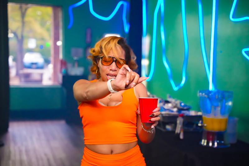 Pointing at the camera with the front door wide open behind